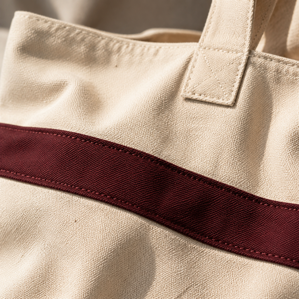 Close-up of a beige tote bag with a brown strap